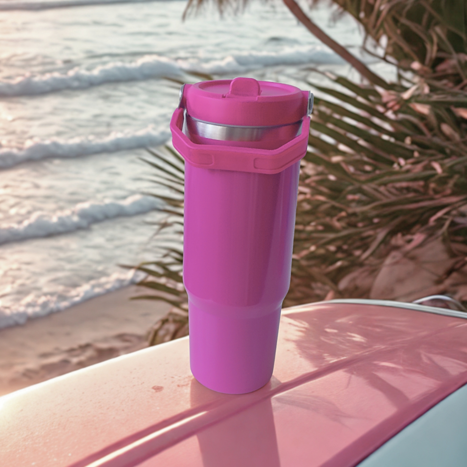 Front view of the Wildberry Pink tumbler with lid closed and handle down, placed on a pink car at the beach