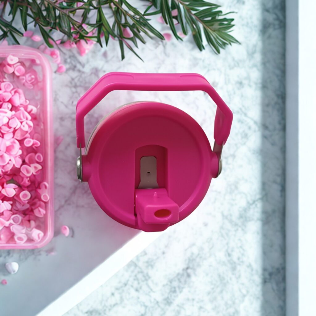 Top view of Wildberry Pink tumbler showing flip straw lid with handle upright, surrounded by pink wax chips and florals