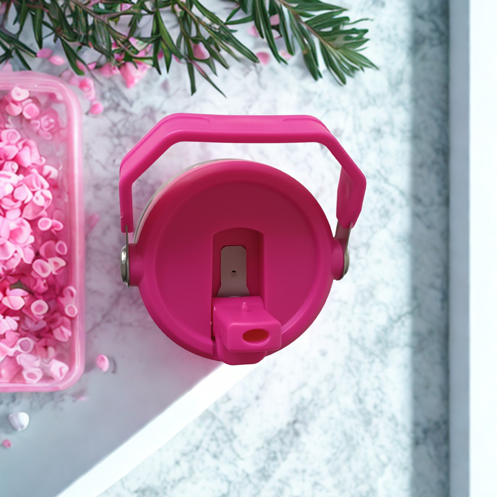 Top view of Wildberry Pink tumbler showing flip straw lid with handle upright, surrounded by pink wax chips and florals